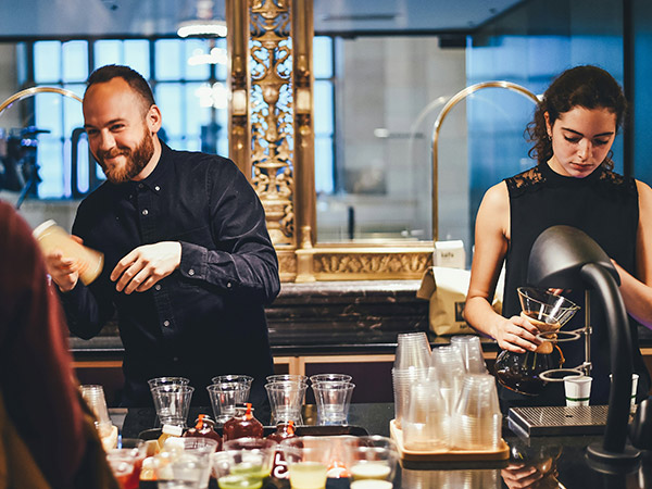 two cafe workers serving coffee