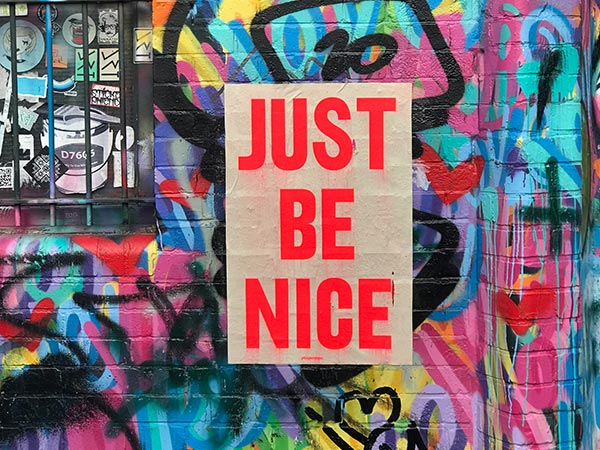 graffiti wall with sign saying just be nice