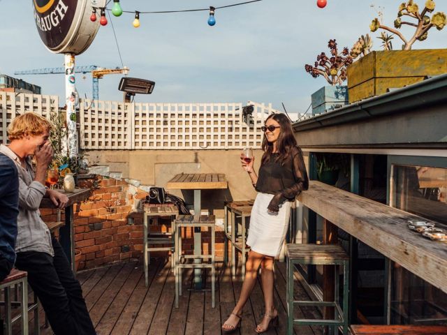 a woman holding a drink atop Marquis of Lorne, Fitzroy