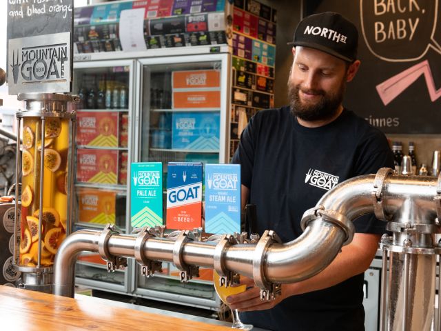 a bartender pouring tap beer at Mountain Goat Brewery, Richmond