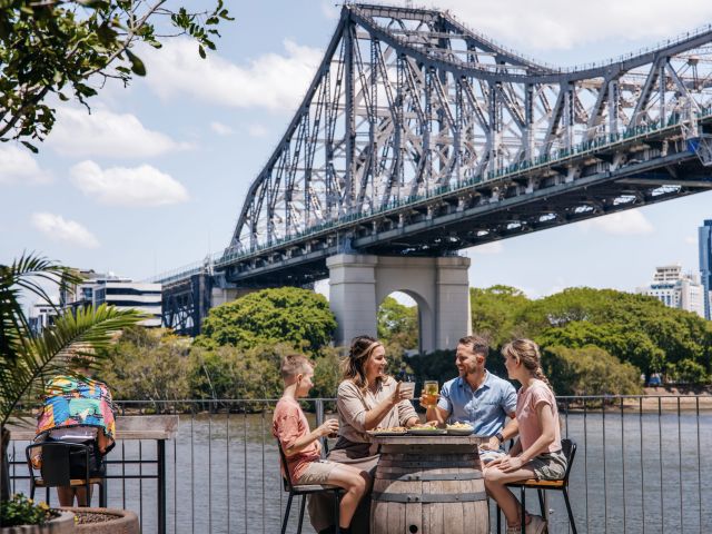a family dining at Felons Brewing Co, Howard Smith Wharves with Story Bridge in the background