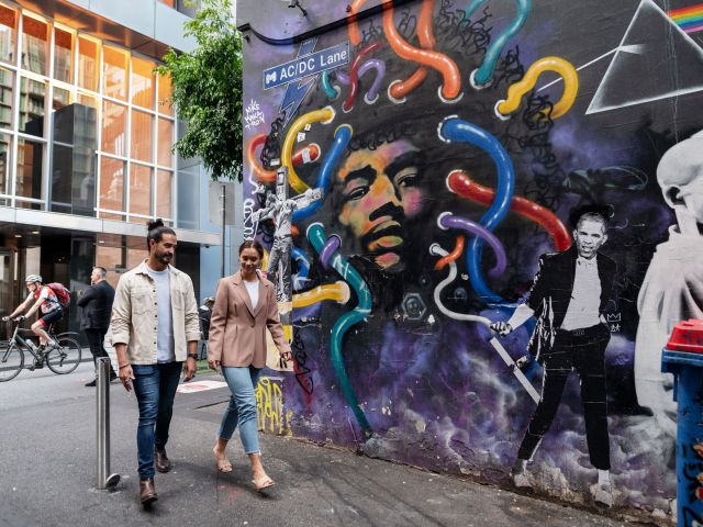 two people walking along the street art-lined AC/DC lane, Melbourne