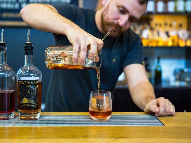 a bartender pouring a drink into a glass at Starward