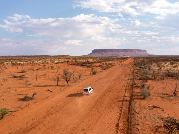 a 4WD driving through the red dirt in Uluru