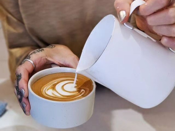pouring milk over a latte cup at Baked Culture, Port Macquarie