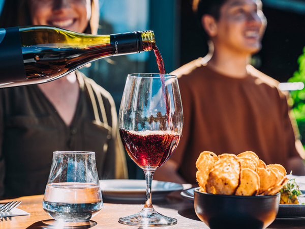 pouring a bottle of Cassegrain wine into a glass, 