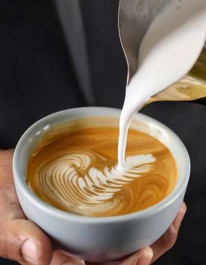 Barista making a cup of coffee latte art