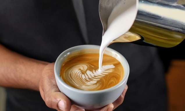 Barista making a cup of coffee latte art