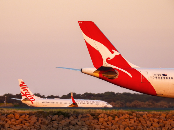 Qantas and Virgin planes on an airport runway