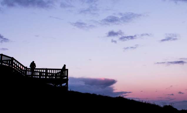 People watching the sun come up from a lookout