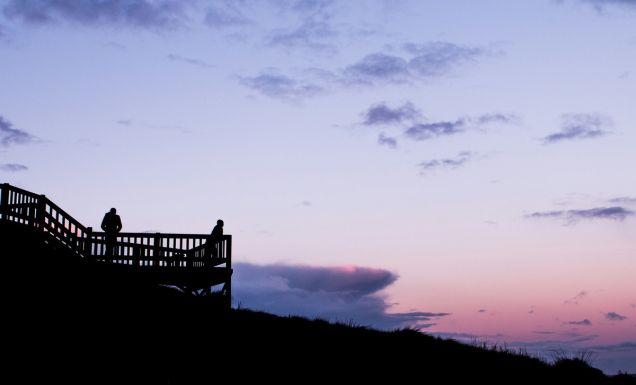People watching the sun come up from a lookout