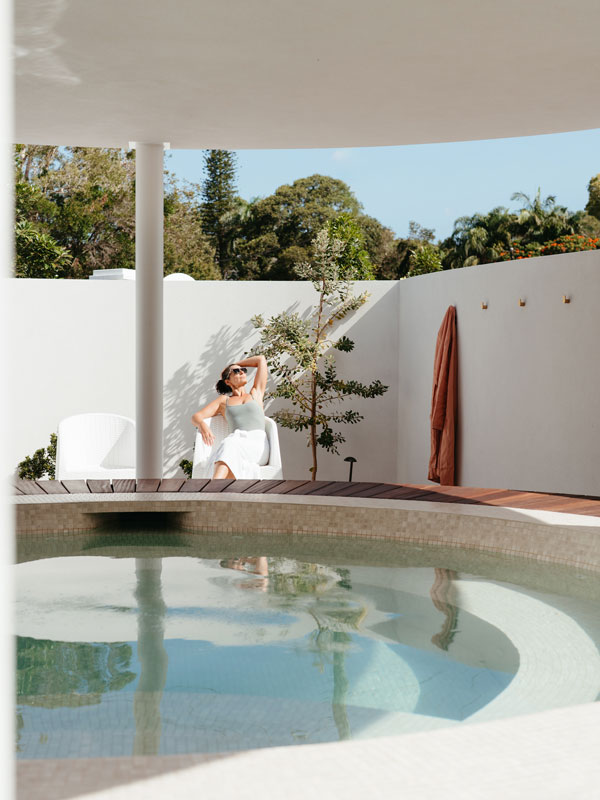 A woman relaxes alongside the baths at Byron Bay Bathhouse
