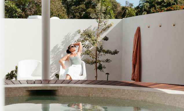 A woman relaxes beside the baths at Byron Bay Bathhouse