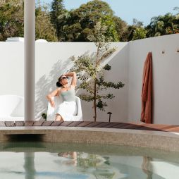 A woman relaxes beside the baths at Byron Bay Bathhouse