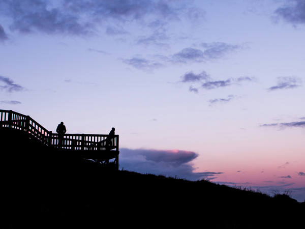 People watching the sun come up from a lookout