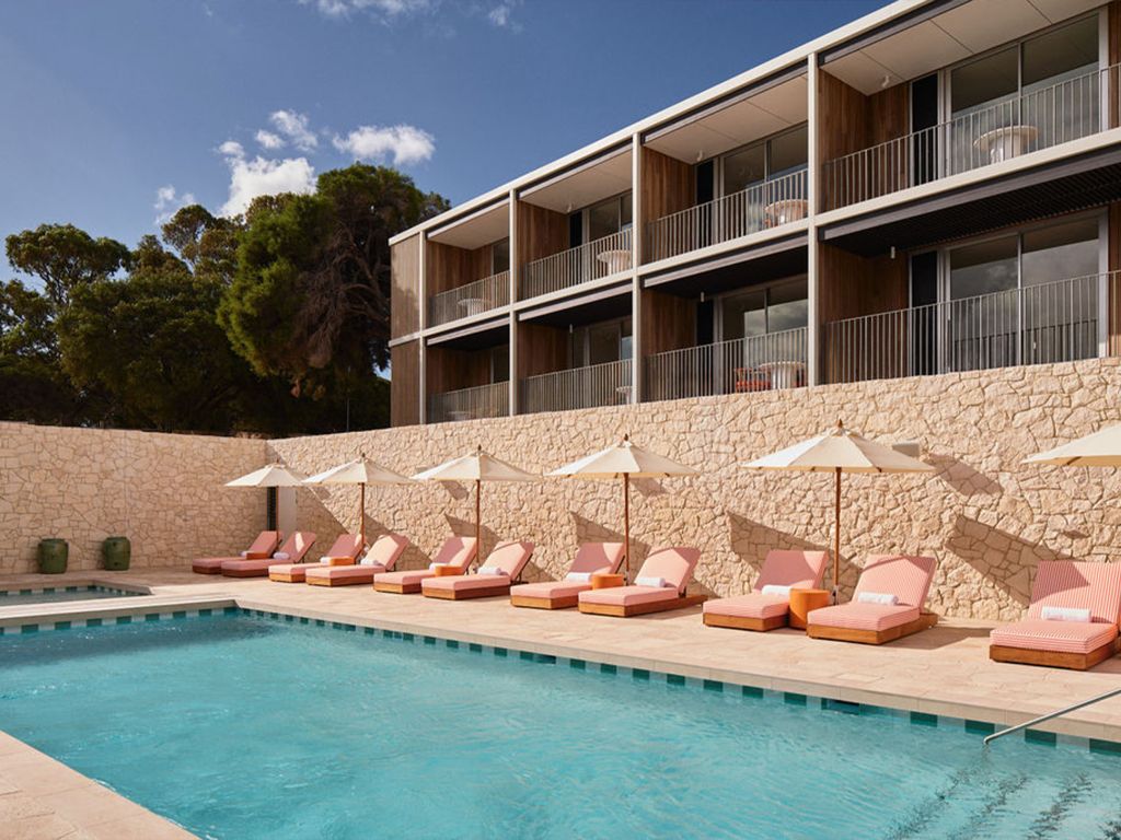 The swimming pool with beach umbrellas and modern wing of The Lodge Wadjemup