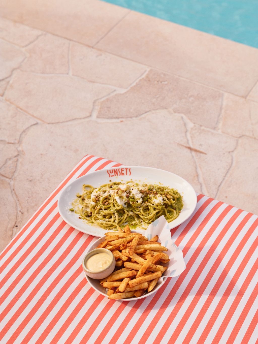 Chips and pasta on a orange and white striped sun lounger