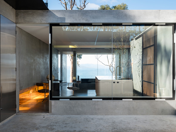 View of Vipp Tunnel from the outside looking through the kitchen to the lounge and out to the ocean