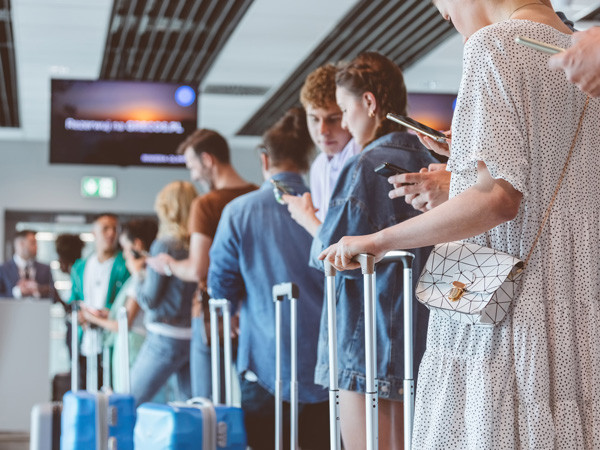 People lining up with luggage at the airport