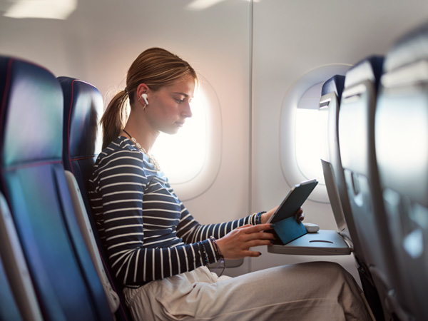 A woman on a plane using her tablet