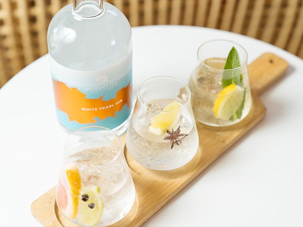 Three gin cocktails with garnishes.