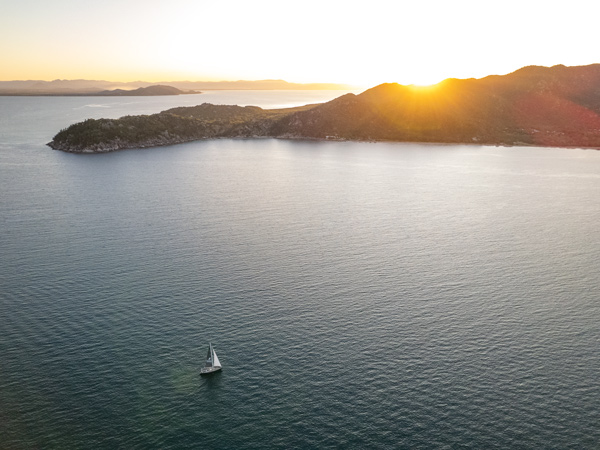 an aerial view of a yacht sailing at sunset, Magnetic Island