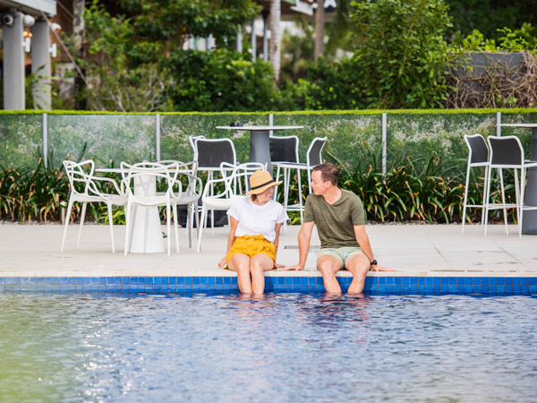 a couple relaxing in the pool at Cairns Harbourside Hotel
