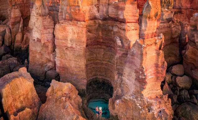A couple stands over a waterhole in the Dampier Peninsula WA