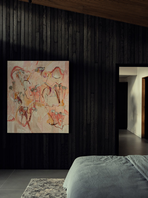 The dark bedroom with a colourful artwork at Kittawa Retreat.