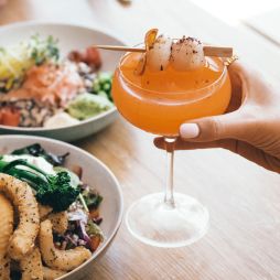 Woman enjoying cocktail and food at Novotel Oasis Resort in Cairns