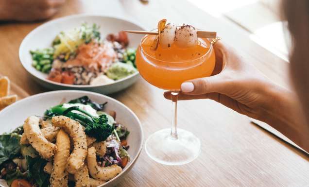 Woman enjoying cocktail and food at Novotel Oasis Resort in Cairns