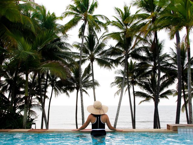a woman relaxing by the pool at Alamanda Palm Cove by Lancemore