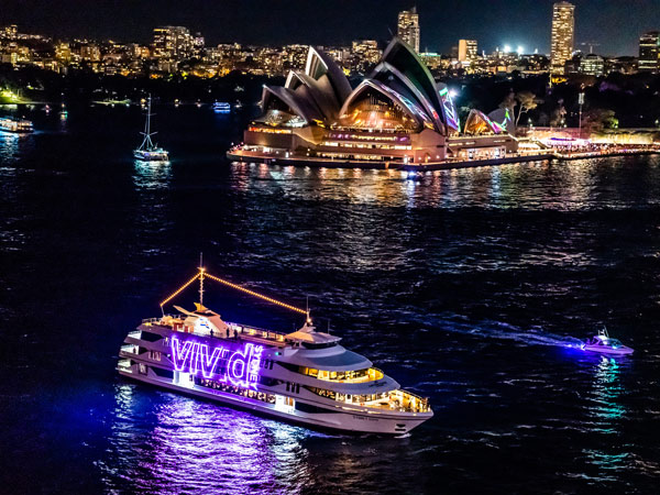 Vivid Sydney cruise sails through Sydney Harbour past the Sydney Opera House during Vivid Sydney