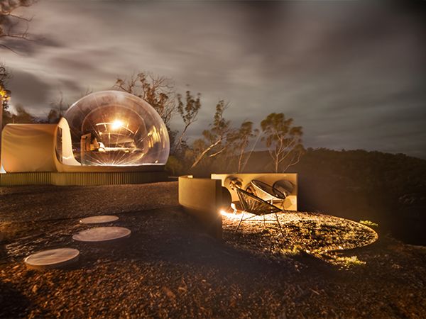 An outdoor glamping set up at night with a firepit.