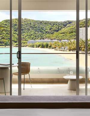 A modern hotel room overlooking a tropical beach