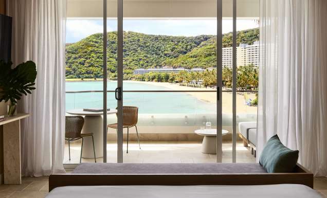A modern hotel room overlooking a tropical beach
