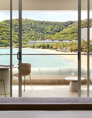 A modern hotel room overlooking a tropical beach