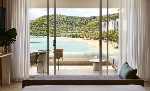 A modern hotel room overlooking a tropical beach