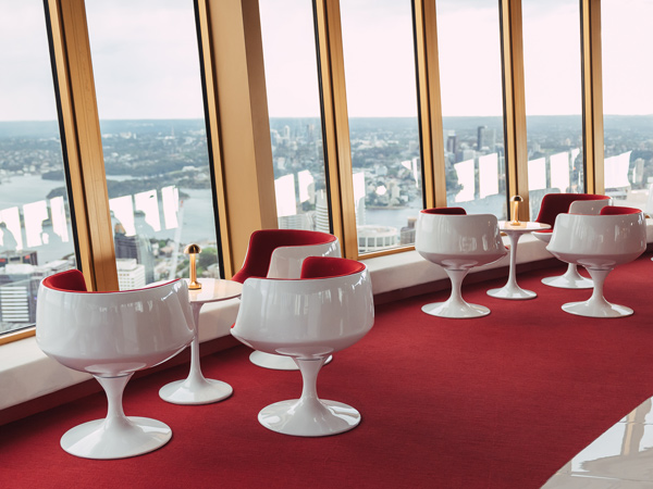 red velvet chairs and white Tulip tables at Bar 83, Sydney Tower