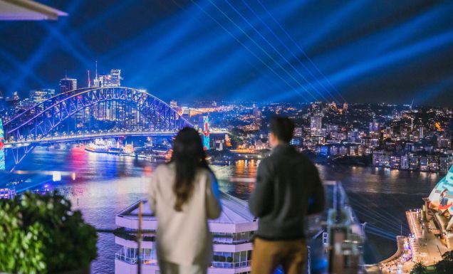 A couple watching the lights of Vivid Sydney at Aster, InterContinental Sydney