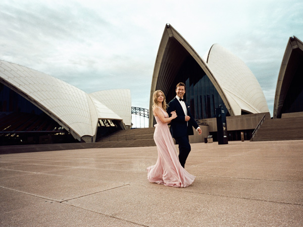 Anyone But You stars Sydney Sweeney and Glen Powell in front of Sydney Opera House