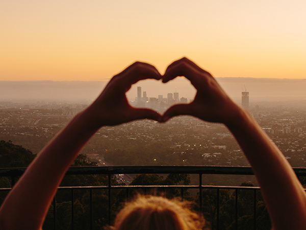 person making a heart from their hands at mt coot-tha lookout
