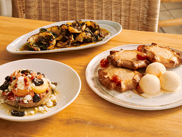 A table laden with Greek mezze dishes share-plate style.