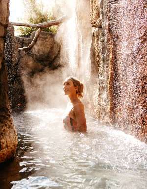 a woman soaking in an outdoor hot spring at Deep Blue Hotel