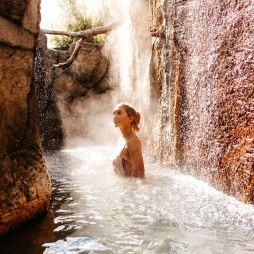 a woman soaking in an outdoor hot spring at Deep Blue Hotel