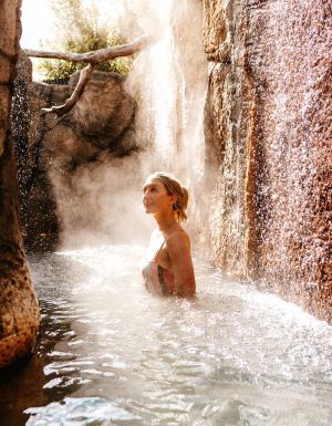 a woman soaking in an outdoor hot spring at Deep Blue Hotel
