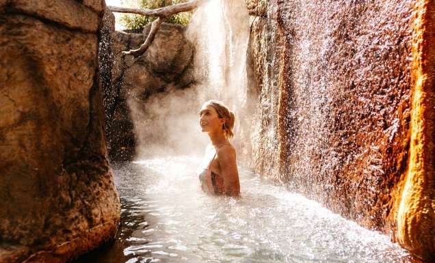 a woman soaking in an outdoor hot spring at Deep Blue Hotel