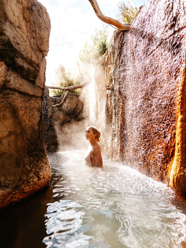 a woman soaking in an outdoor hotspring at Deep Blue Hotel