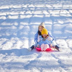 Two children tobogganing at Corin Forest