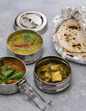 A retro Indian tiffin lunch box filled with vegetarian food. And chapati.